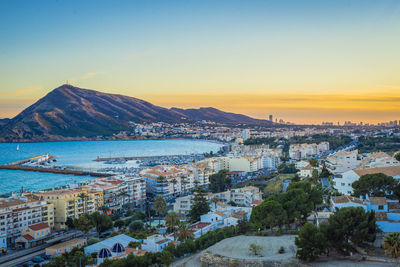 High angle view of city by sea against sky