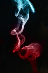 Close-up of smoke moving against black background