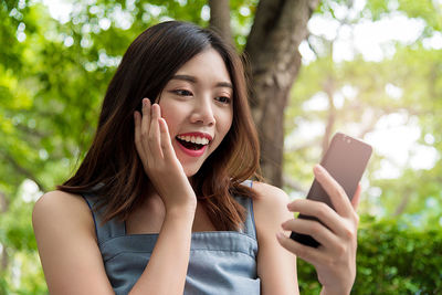 Portrait of young woman using mobile phone outdoors