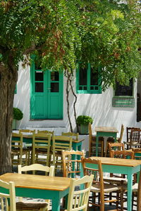 Empty chairs and tables against trees