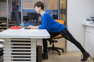 Young woman stretching in the office