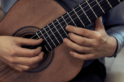 Midsection of man playing guitar