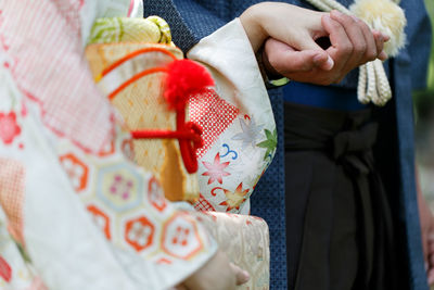 Low section of woman holding bouquet