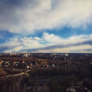 Aerial view of city against cloudy sky