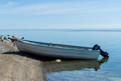 Boat moored on sea against sky