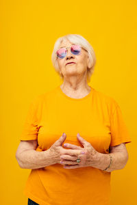 Portrait of woman with face paint against yellow background