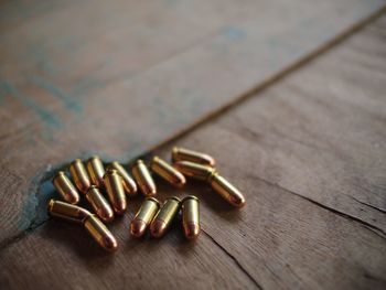 High angle view of bullets on wooden table