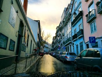 Wet city street against sky