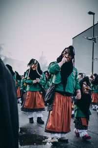 Group of people in traditional clothing against clear sky
