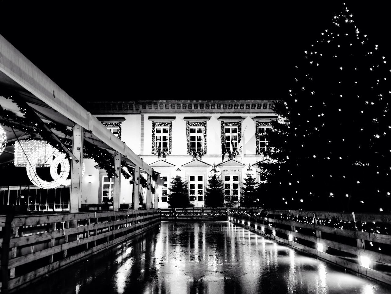 architecture, built structure, night, illuminated, text, transportation, building exterior, western script, water, reflection, bridge - man made structure, clear sky, city, indoors, city life, railroad station, connection, building, street, incidental people