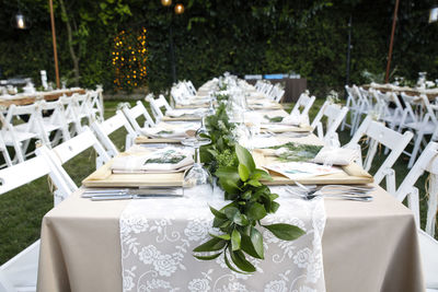 Chairs and tables arranged at lawn during ceremony