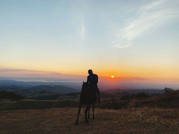 Full length of friends on land against sky during sunset