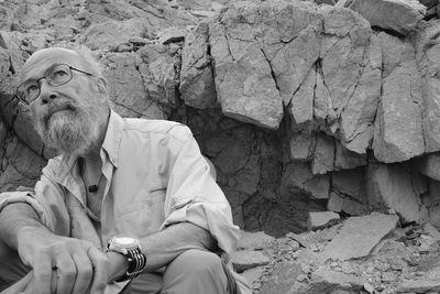 Portrait of senior man sitting on rock