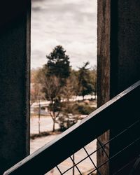 Close-up of railing by window against sky