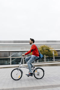 Casual businessman commuting in the city, using his folding bike