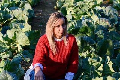 Beautiful young woman with plants in foreground