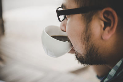 Close-up of man drinking coffee at sidewalk cafe