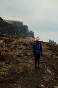 Rear view of man walking on mountain against sky