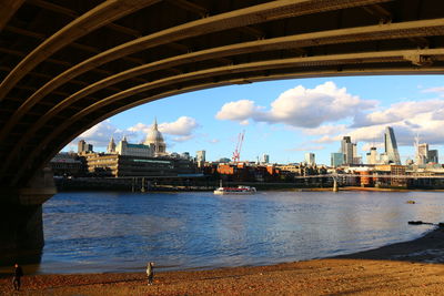 Scenic view of river by city against sky