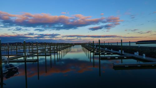 Pier on lake against sky during sunset