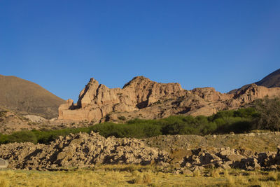 Scenic view of rocky mountains against clear blue sky