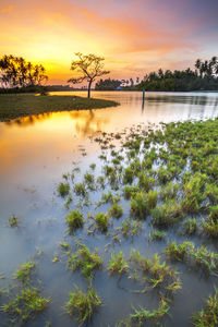 Scenic view of lake against sky at sunset