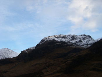 Low angle view of snowcapped mountains against sky