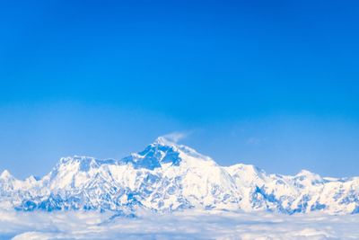 Scenic view of snowcapped mountains against clear blue sky