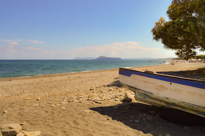 Boat moored on beach against sky