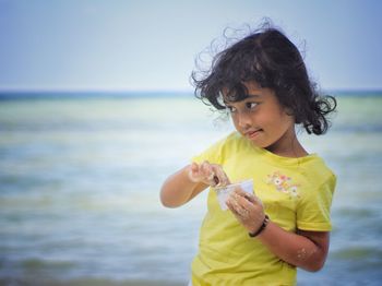 Happy girl playing sand on beach