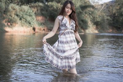 Portrait of young woman standing in lake