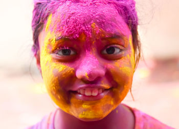 Close-up portrait of girl with holi colors on face