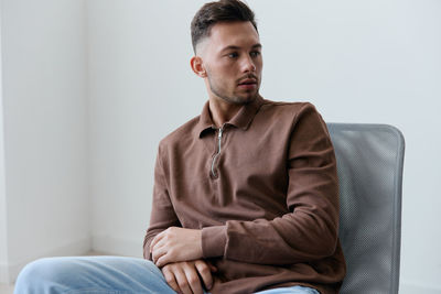 Young man sitting on sofa at home