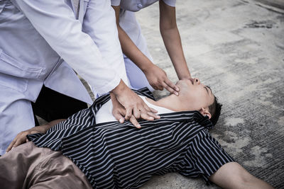 Nurse examining man lying outdoors