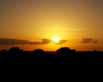 Silhouette landscape against orange sky