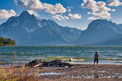 Man standing at beach against sky