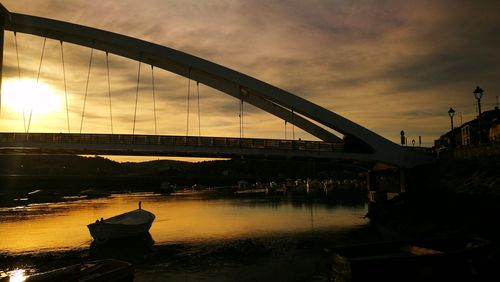 Bridge over river against sky during sunset