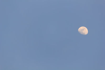 Low angle view of moon against clear blue sky