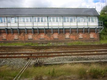 Railroad tracks by building against sky