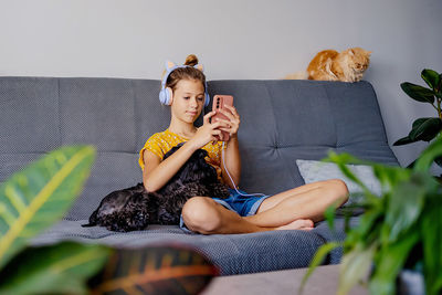 Portrait of young woman sitting on sofa at home