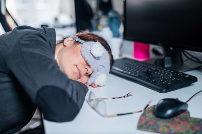 Woman resting on desk in office