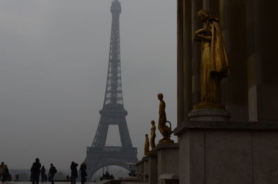 Statue in city against sky