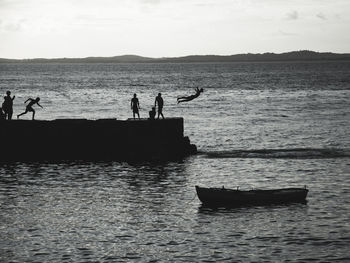 Young people jumping from the pier of porto da barra