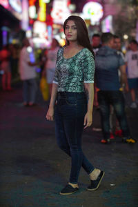 Portrait of young woman standing on street