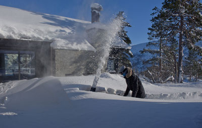 Man removing snow outside house