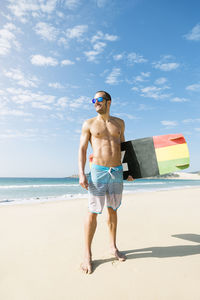 Full length of shirtless man standing on beach