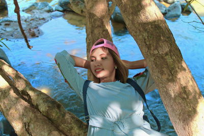 Portrait of woman against tree trunk