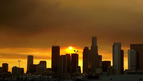 City skyline against cloudy sky during sunset