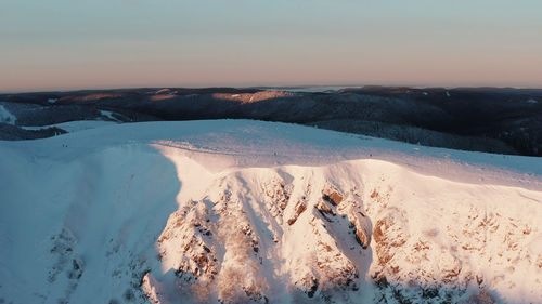 Panoramic view of snowcapped mountains against sky during sunset