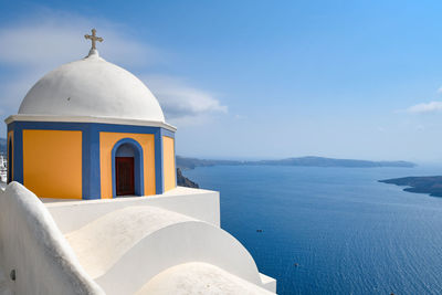 View of church by sea against sky